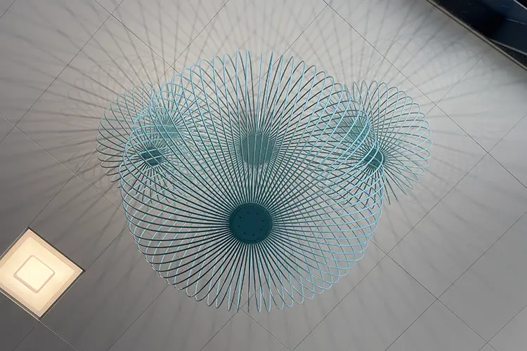 takhängande runda sfärer i turkos färg vars skuggor speglas i taket 
